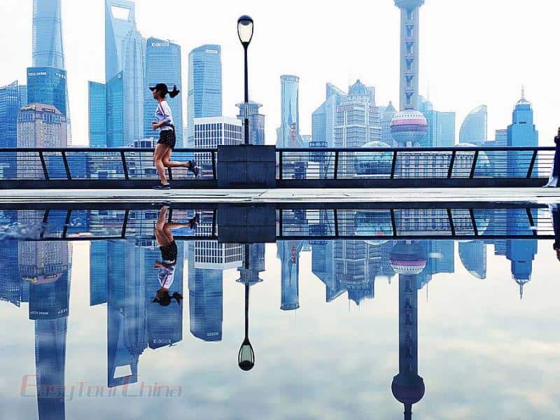 A girl running before Shanghai World Finanical Center in lujiazui