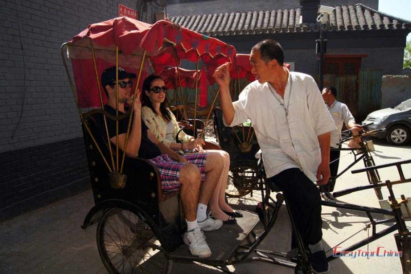 Couple take a pedicab tour of hutong