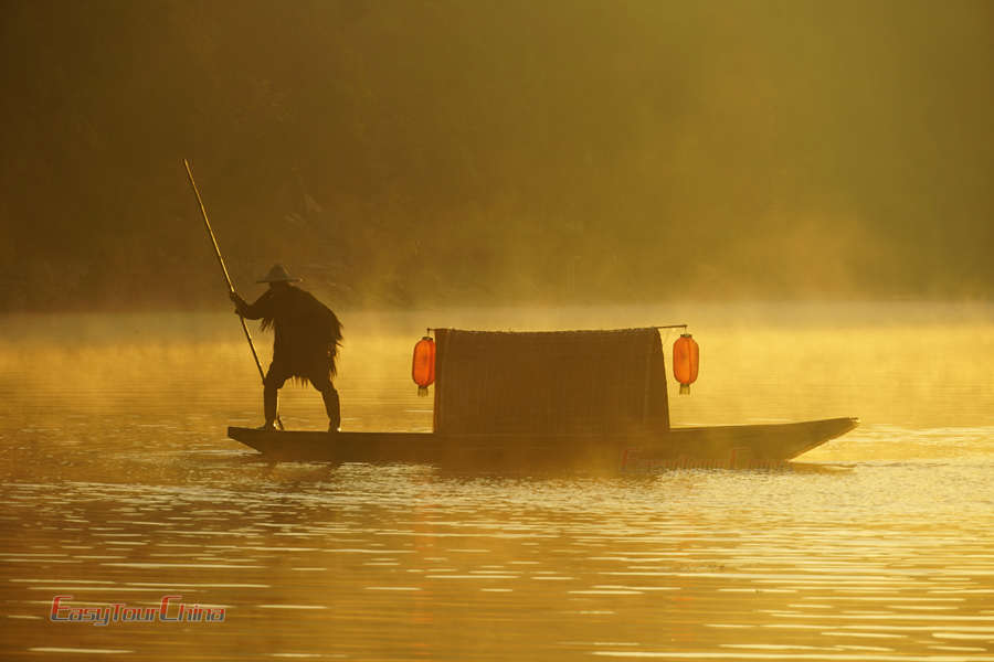 Capture a fisherman in the morning mist in Wuyuan